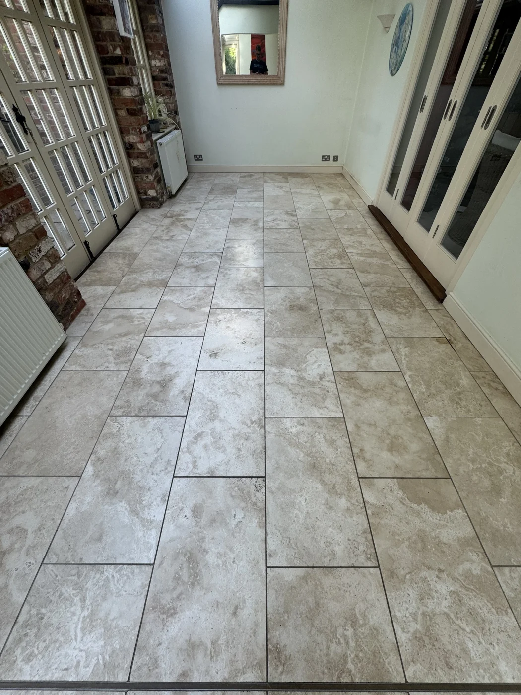 Tiled floor project, showing the floor and grout lines in an adjoining room